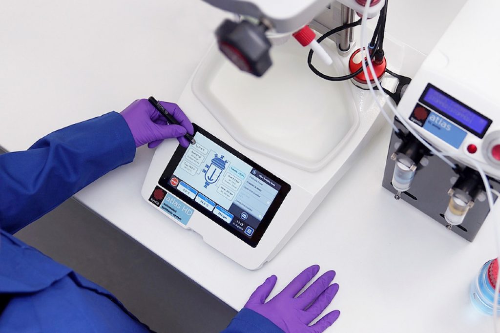 Syrris Atlas HD with Syringe Pump, chemist using touchscreen